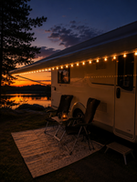 Tänd ljusslinga på husvagnsmarkisen en kväll med campingstolar och matta framför – belysning för uteplatsen