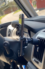 Svart mobilhållare monterad i bil med telefon i hållaren, passar husbil och personbil.